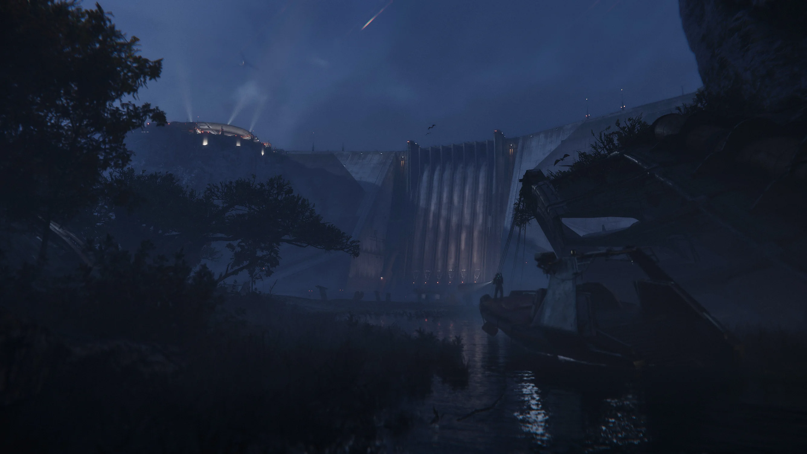 Illuminated dam above a wooded landscape